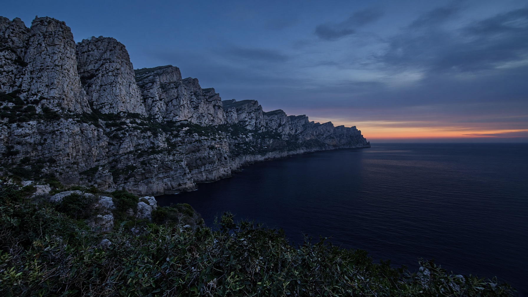 Limestone cliffs of the Corsican coast at blue hour.